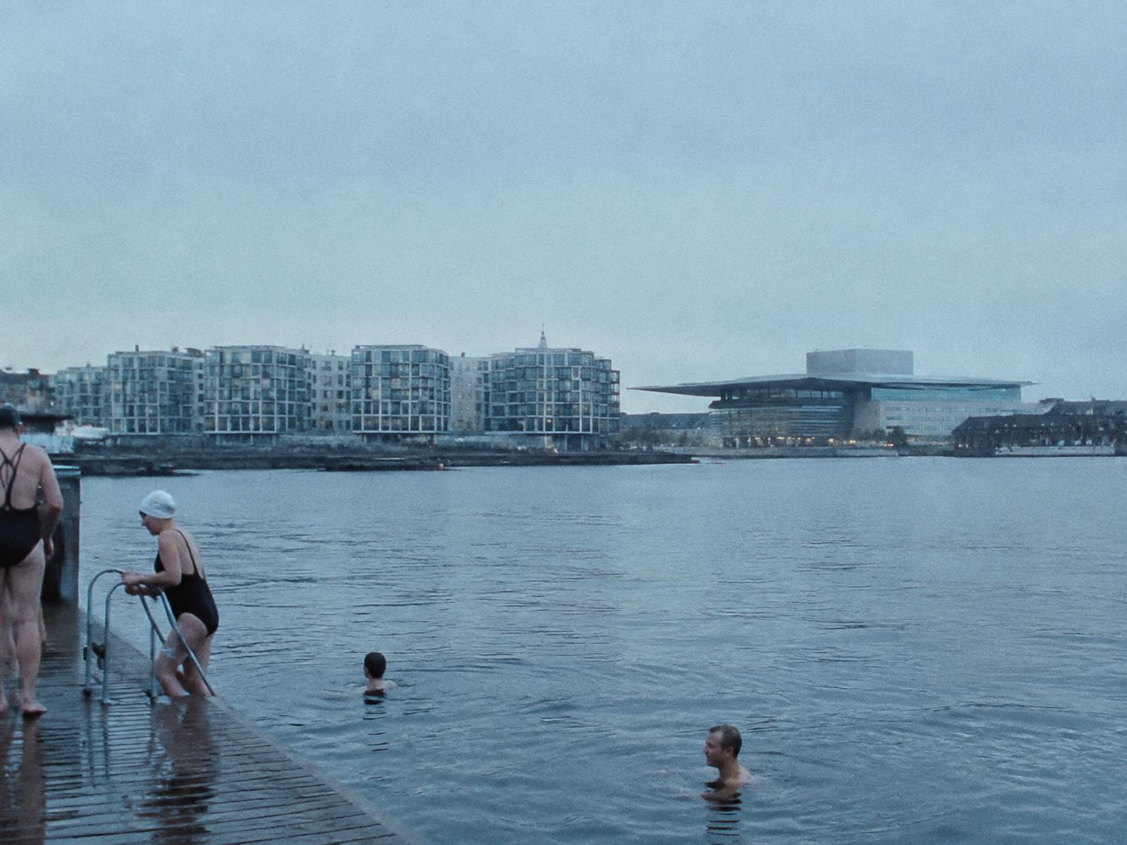 Swimmers at a Copenhagen harbour bath in pale Nordic light